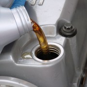 An image of oil being poured into a car