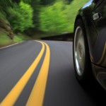 An image of a car driving along a road