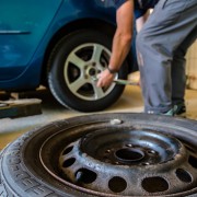 An image of a man changing the tyre on a car